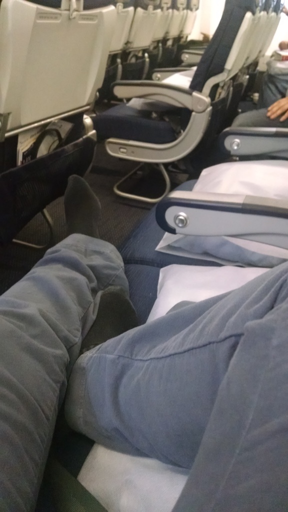 Legs across empty airplane seats